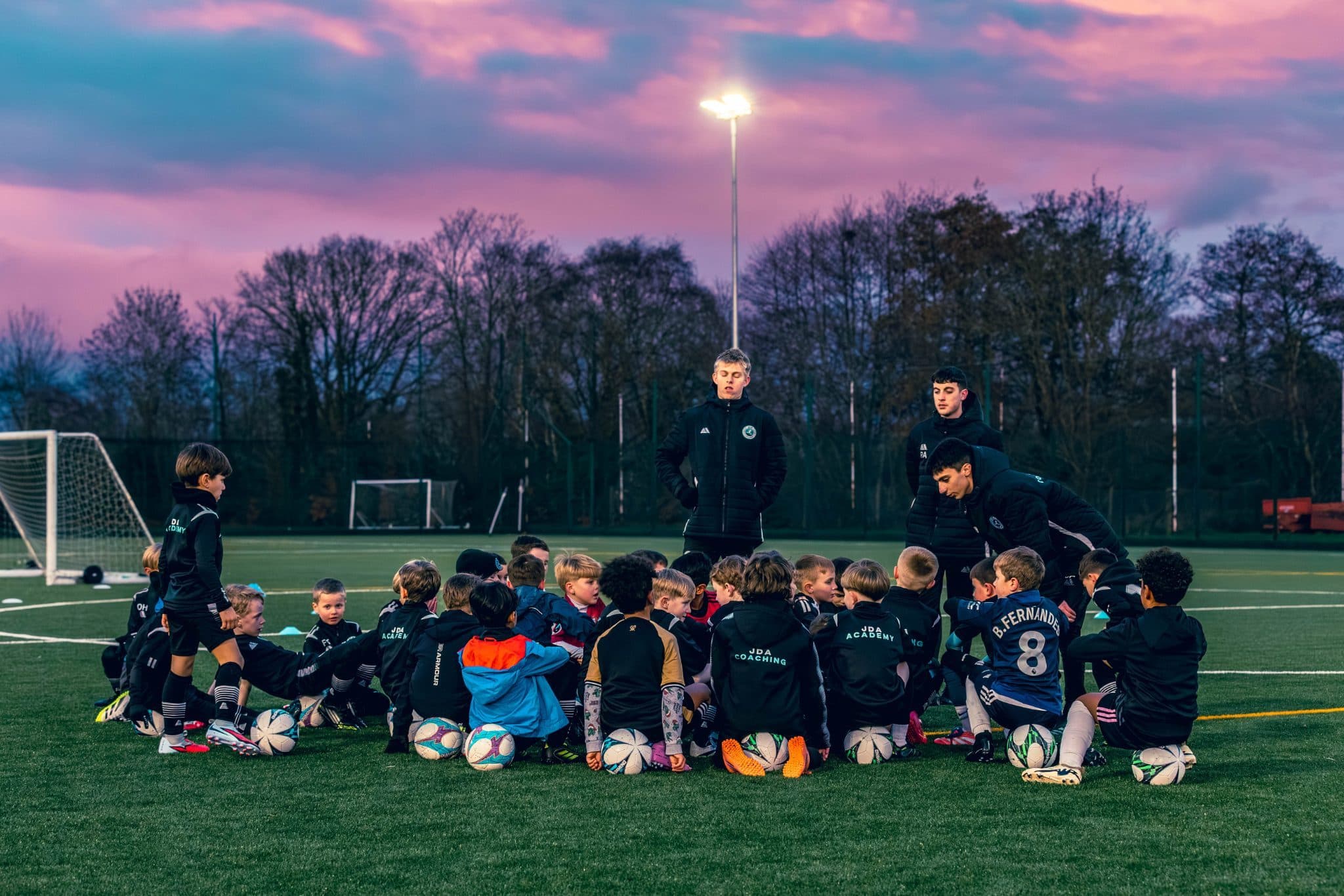 A JDA Academy squad and coaches gathered together at dusk